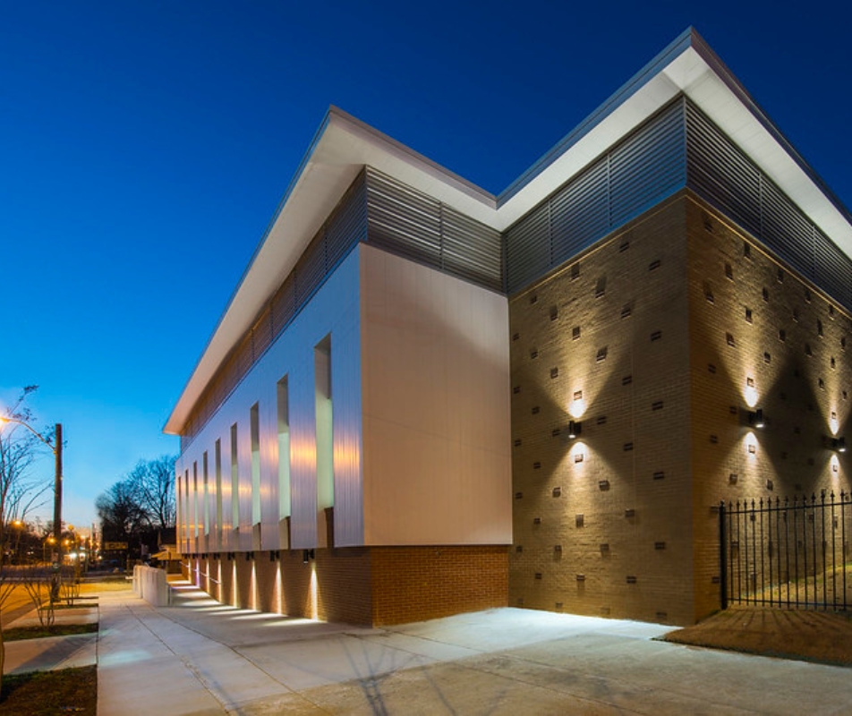 outside of a modern school at dusk lit up by dramatic lighting