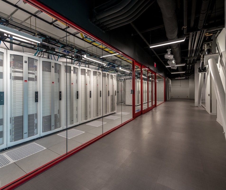 data center server room behind glass wall down hall in perspective