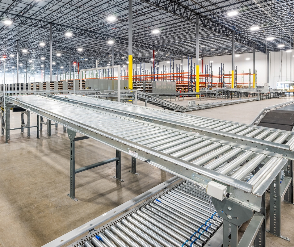 warehouse with conveyer belt lit up by overhead lighting